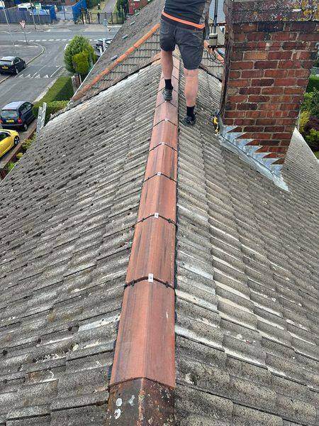 The ridge tiles refixed, clips showing between each one