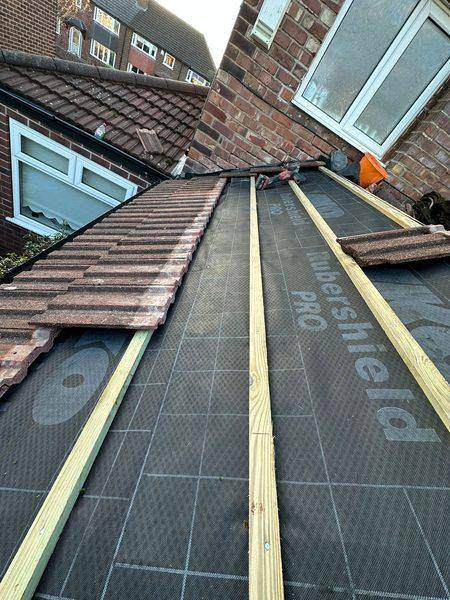 Fresh battens running up the slope over the new breathable underlay
