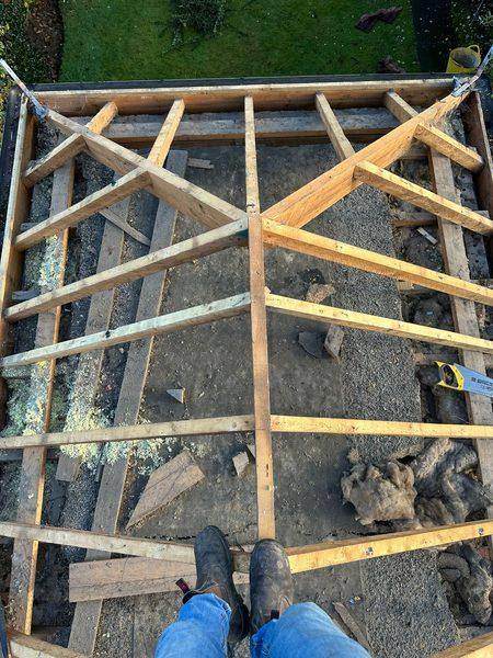 The roof open to its bare rafters, debris still lying on the ceiling below