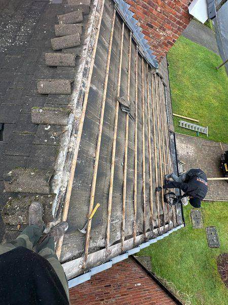 Looking down on the stripped slope, old tiles stacked clear to one side