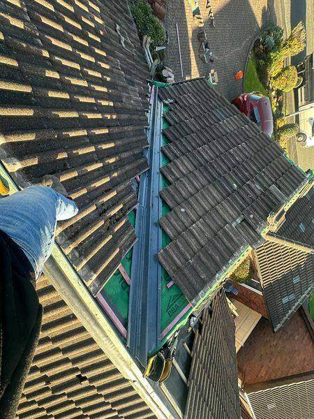 New tiles chasing the membrane up the slope, valley cut in below