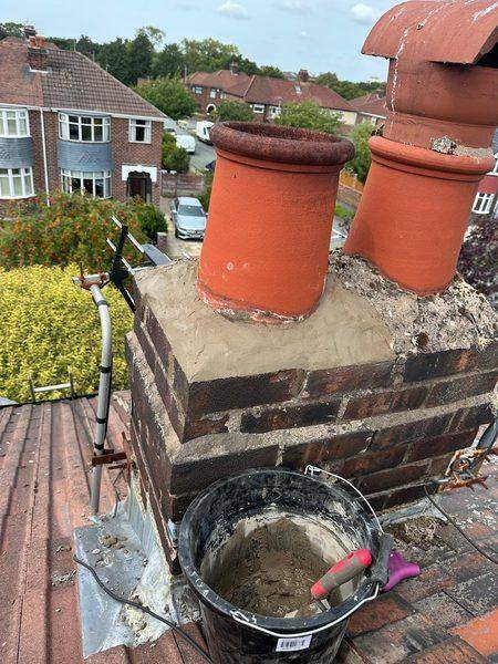 Both pots re-bedded in fresh mortar at the top of the stack