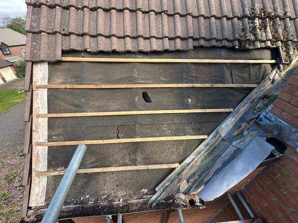 Old bitumen felt below the tile line, torn and holed through