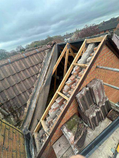 Covering off and the roof timbers open, tiles stacked for reuse