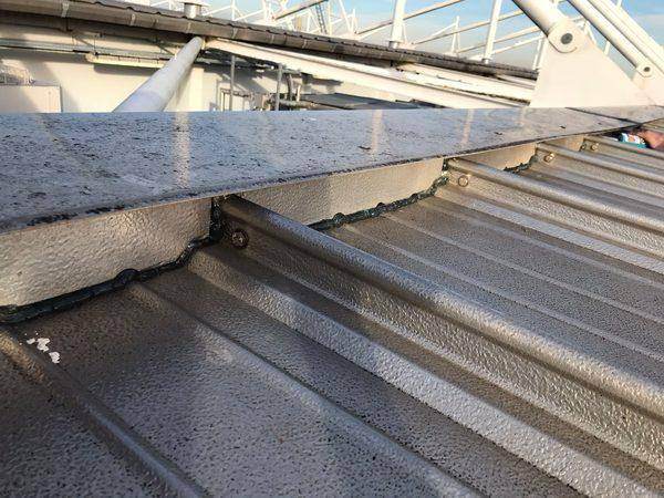 Close-up of the sealed bead where coping meets sheet, round the fixings